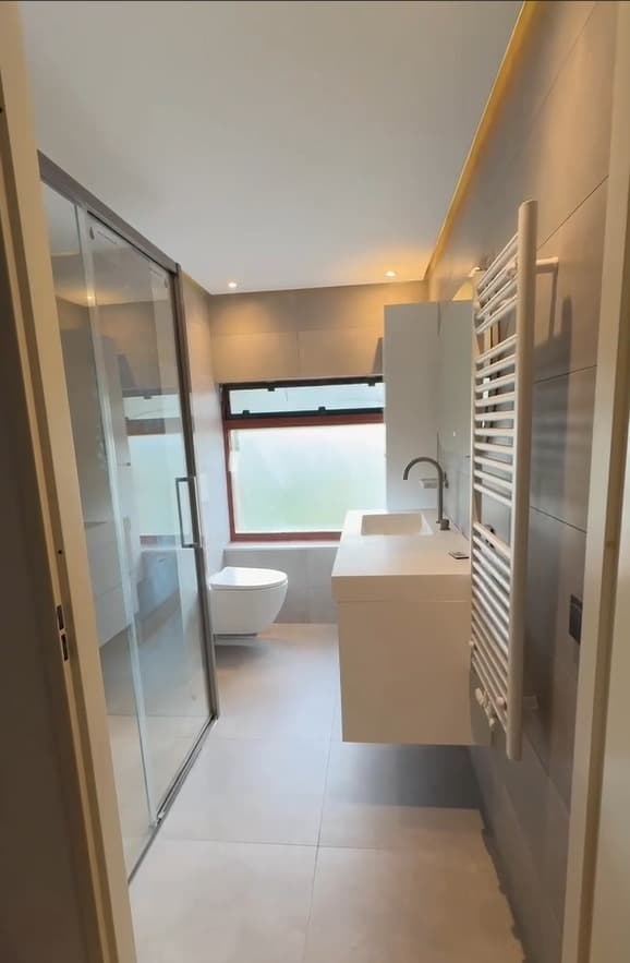 Gerenoveerde badkamer met douche, wastafelmeubel en handdoekradiator